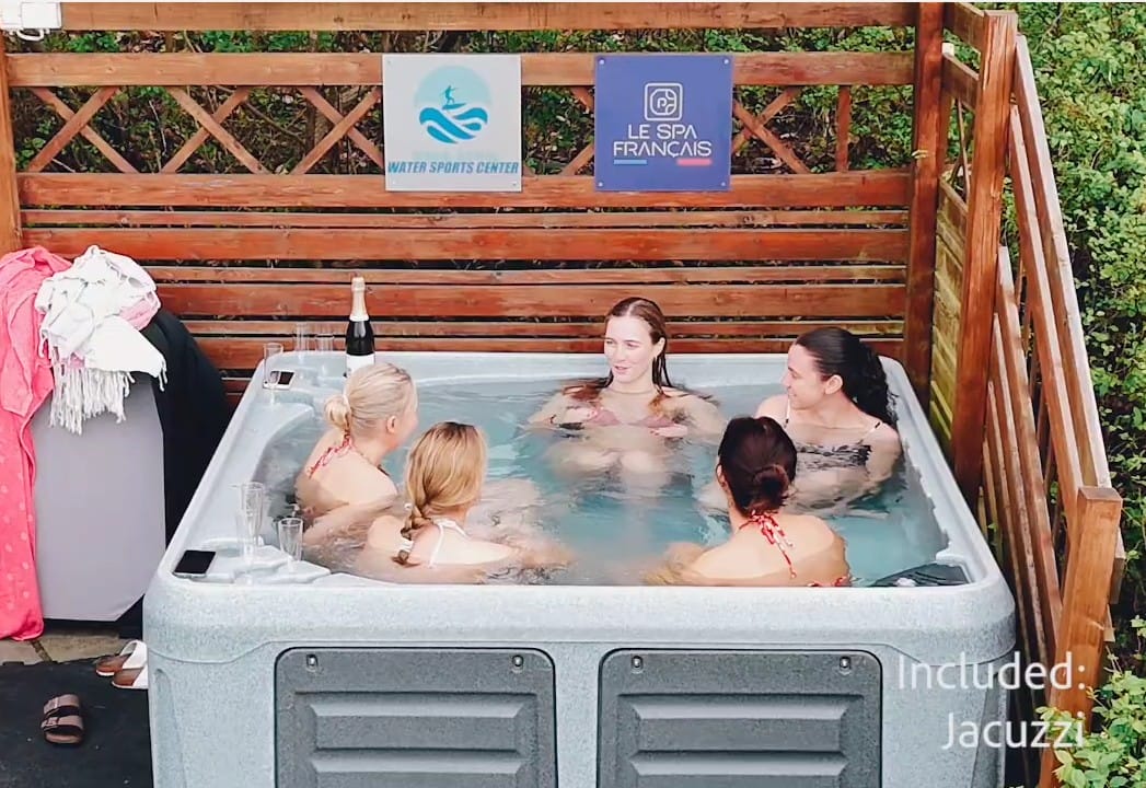 Cinq personnes réunies dans un spa extérieur devant une enseigne Le Spa Français